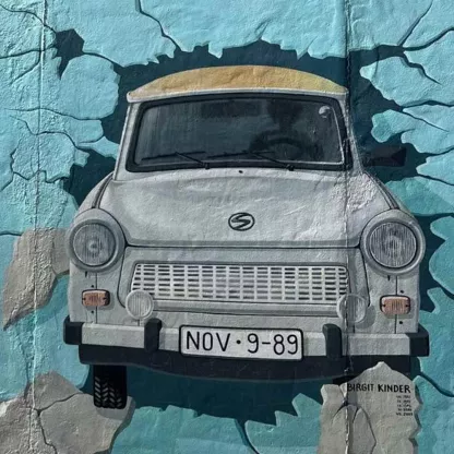 street art depicting a car breaking through a wall towards the viewer